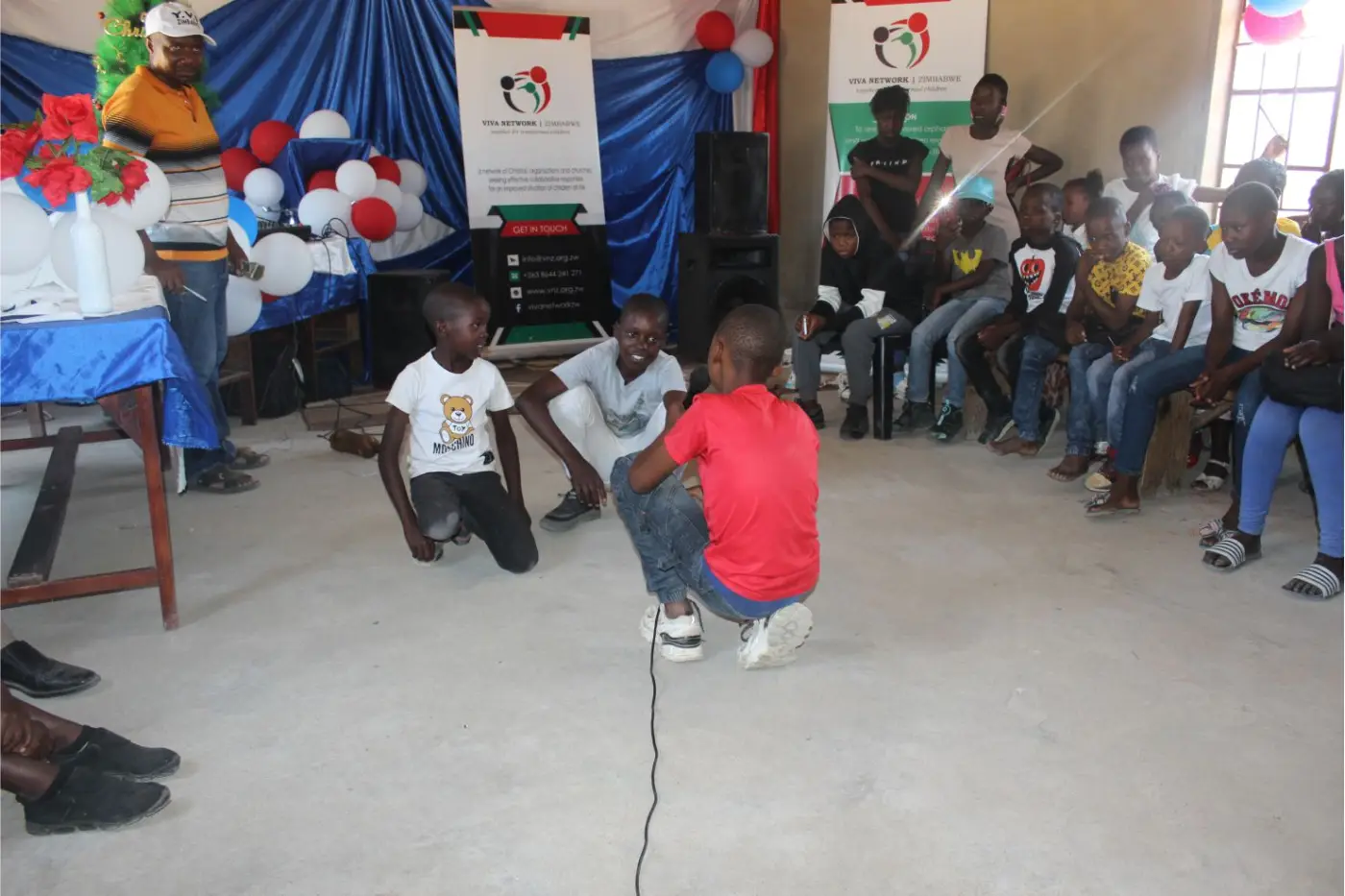 Children and community members sharing an organised celebration