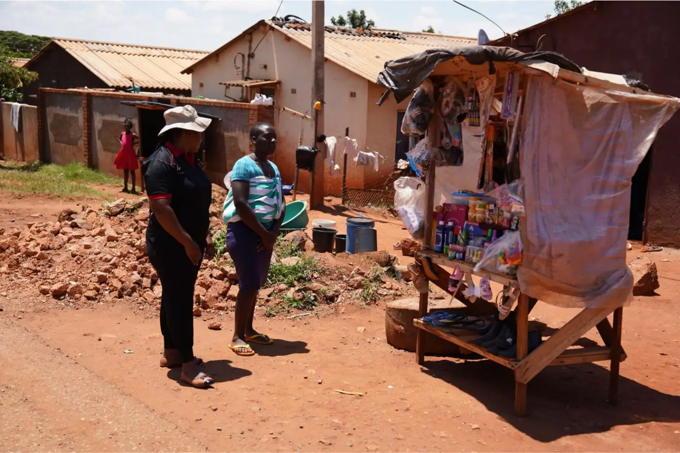 A community entrepreneur beside her neighbourhood trading stall
