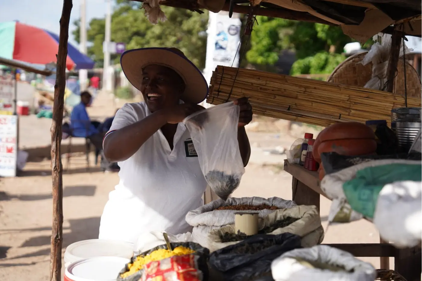 A livelihoods beneficiary serving a customer at her market stall